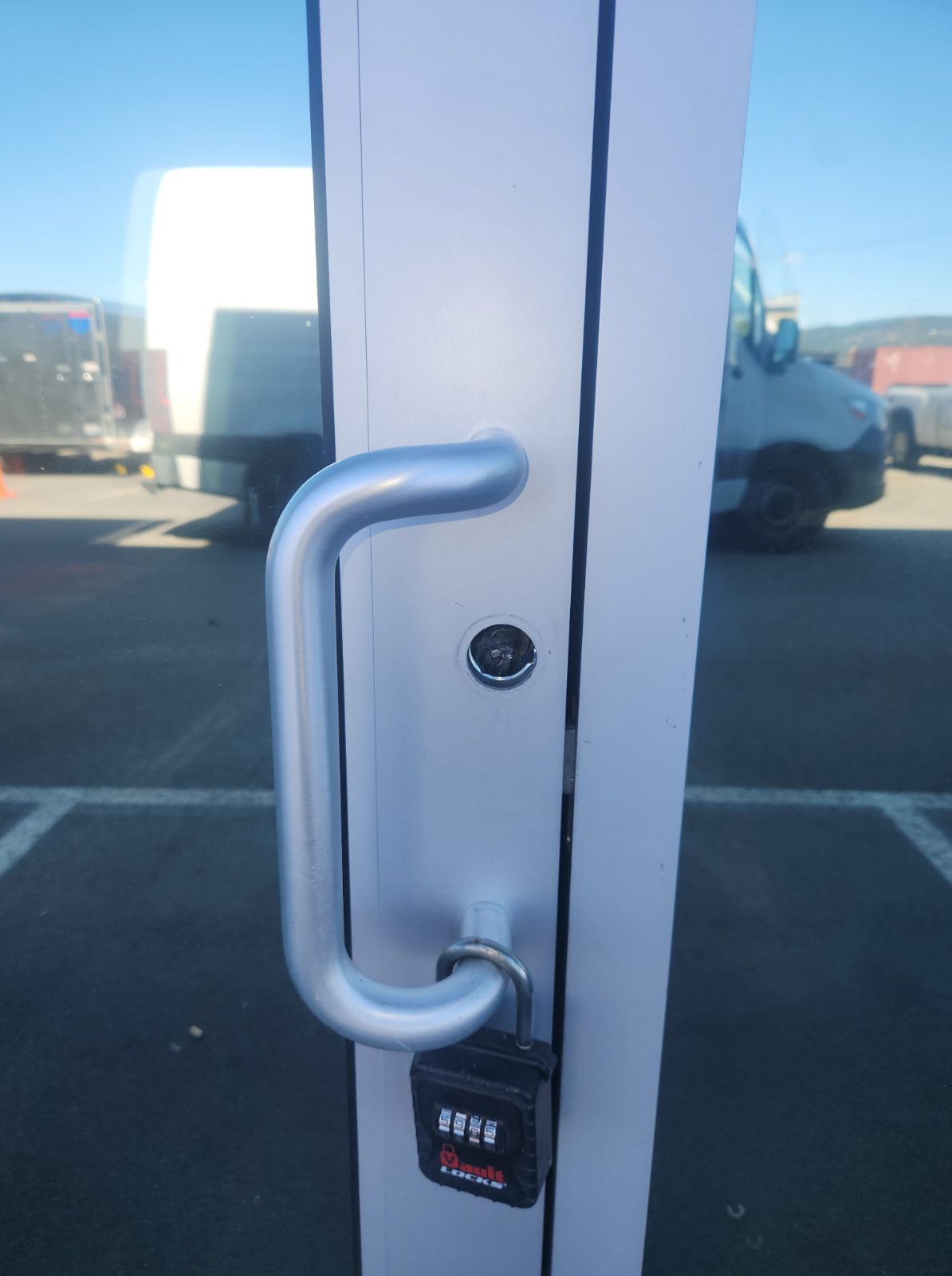 RC Roofing front door with damaged mortise lock and temporary padlock after failed locksmith attempt